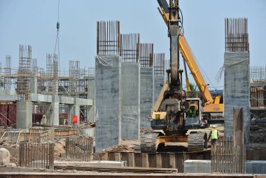 SELANGOR, MALAYSIA 15 Mart 2016: İnşaat alanında çarşaf yığını cofferdam sürücü makine. Makine titreşimli hidrolik kolu kullanarak çarşaf yığınını yere itti. İşçi kontrolü.