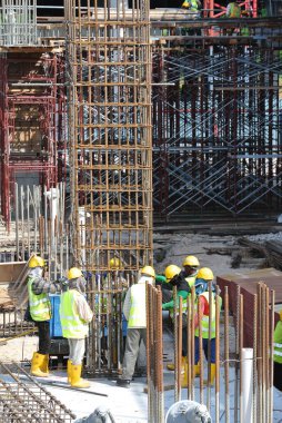 MALACCA, MALAYSIA - 29 Mart 2016: Malezya 'nın Malacca kentindeki inşaat alanında çelik takviye barı üreten inşaat işçileri. Destek çubuğu küçük bir kabloyla birbirine bağlanmış..  
