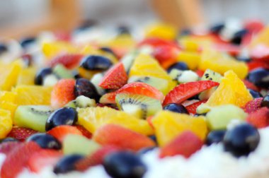 Lezzetli beyaz kremanın üstüne dilimle ve meyve kes.