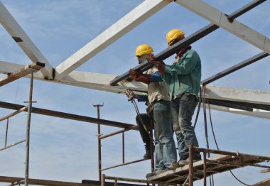 SELANGOR, MALAYSIA - 09 Aralık 2015: İnşaat alanında koruyucu maske takan kaynakçı. 