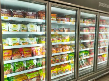 KUALA LUMPUR, MALAYSIA - 21 Haziran 2021: Donmuş hamur işleri ticari paketlerde paketlenir ve süpermarketin içindeki soğutucu bir kutuda sergilenir. Markaya göre sıralanır ve fiyat etiketi ile etiketlenir.