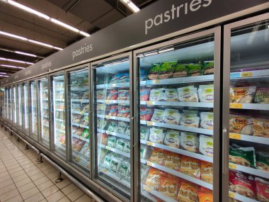 KUALA LUMPUR, MALAYSIA - 21 Haziran 2021: Donmuş hamur işleri ticari paketlerde paketlenir ve süpermarketin içindeki soğutucu bir kutuda sergilenir. Markaya göre sıralanır ve fiyat etiketi ile etiketlenir.