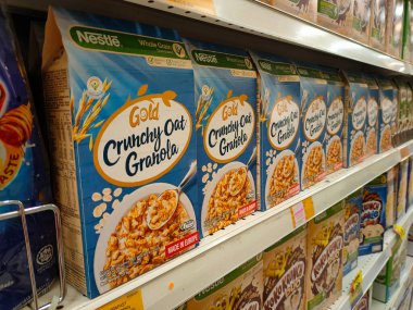 KUALA LUMPUR, MALAYSIA - AĞUSTOS 4, 2021: Karton kutuda paketlenmiş tahıl gevreği ve plastik pakete odaklanmış. Dev süpermarketlerde raflarda sergileniyordu. Damgasına göre sıralanmış. Hepsinin bir fiyatı var.. 