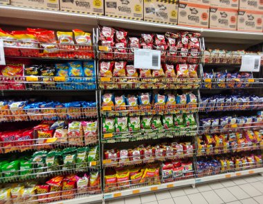 JOHOR, MALAYSIA -18 Nisan 2021: Seçici bir şekilde raftaki çeşitli markalı abur cuburlar ve abur cuburlar paketlenip süpermarkette satışa sunulmaya çalışıldı. Her birinin kendi fiyat etiketi var.. 