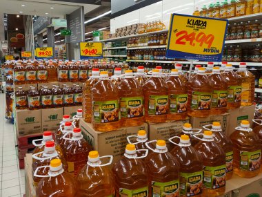 JOHOR, MALAYSIA -14 Nisan 2021: Süpermarkette satılmak üzere işlenmiş palmiye tohumundan yapılan pişirme yağına odaklandı. Müşterinin seçmesini kolaylaştırmak için markaya göre sıralanır. 