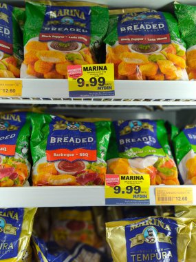 JOHOR, MALAYSIA -APRIL 22, 2021: Dev süpermarketin içindeki soğutucu buzdolabına yerleştirilmiş çeşitli markalarda tavuk nugget ticari ambalajına odaklanmış.