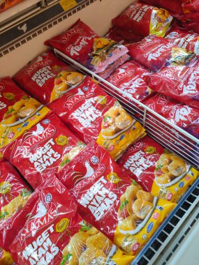 JOHOR, MALAYSIA -APRIL 22, 2021: Dev süpermarketin içindeki soğutucu buzdolabına yerleştirilmiş çeşitli markalarda tavuk nugget ticari ambalajına odaklanmış.