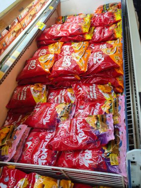 JOHOR, MALAYSIA -APRIL 22, 2021: Dev süpermarketin içindeki soğutucu buzdolabına yerleştirilmiş çeşitli markalarda tavuk nugget ticari ambalajına odaklanmış.