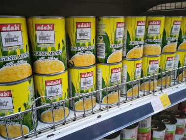 SEREMBAN, MALAYSIA - 4 Haziran 2021: Ticari ambalajda konserve edilmiş tatlı mısırlara odaklanıldı. Pişmiş bile. Markaya göre sıralanmış ve fiyat etiketi var..