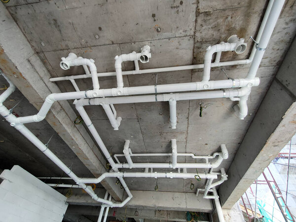 PENANG, MALAYSIA -JANUARY 5, 2021: Sewerage pipes from the toilet above are interconnected under the floor soffit. Installed in gradient and gravity flow. Channeled to the main sewer line. 