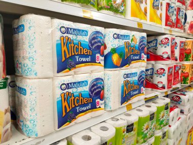 PENANG, MALAYSIA -JANUARY 2, 2022: Selective focused on bathroom tissue & kitchen towel on display for sale in a supermarket. Sorted by brand and labeled with a price tag.