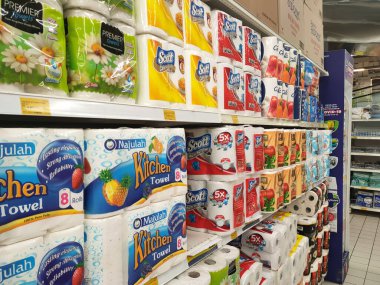 PENANG, MALAYSIA -JANUARY 2, 2022: Selective focused on bathroom tissue & kitchen towel on display for sale in a supermarket. Sorted by brand and labeled with a price tag.