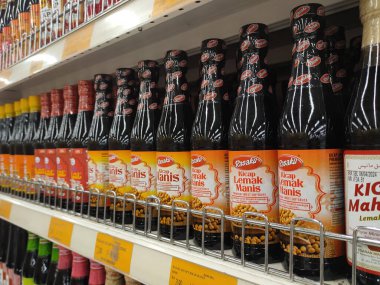 PENANG, MALAYSIA -5 Mart 2021: Pişirme malzemesi olarak kullanılan soya sosunun çeşitli türleri süpermarketlerde satılıyor. Markayla sınıflandırıldı ve fiyat etiketi ile etiketlendi..