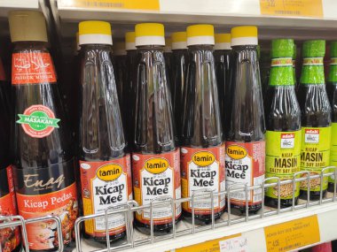 PENANG, MALAYSIA -5 Mart 2021: Pişirme malzemesi olarak kullanılan soya sosunun çeşitli türleri süpermarketlerde satılıyor. Markayla sınıflandırıldı ve fiyat etiketi ile etiketlendi..
