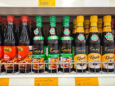 PENANG, MALAYSIA -5 Mart 2021: Pişirme malzemesi olarak kullanılan soya sosunun çeşitli türleri süpermarketlerde satılıyor. Markayla sınıflandırıldı ve fiyat etiketi ile etiketlendi..