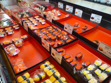 SEREMBAN, MALAYSIA - 29 HAZİRAN 2022: Soğutucuda sergilenmek üzere suşi sergilenmeye odaklanmış. Tepside türüne göre ayrılır ve müşterilerin rahatlığı için bir fiyat etiketi yerleştirilir.