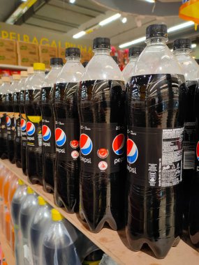 PENANG, MALAYSIA - 18 Mart 2021: Hafif içecekler veya karbonatlı içecekler büyük süpermarketin içindeki raflarda satılığa çıkarıldı. Müşterinin satın almasını kolaylaştırmak için markaya göre sıralanır.