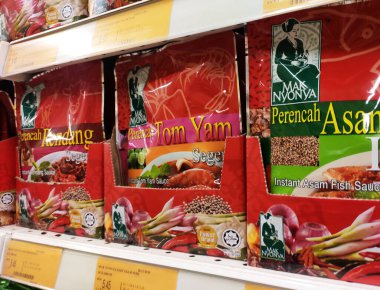 MELAKA, MALAYSIA -HAZİRAN 18, 2021: Baharatlara odaklı seçilen ürünler ticari paketlerde satılıyor ve süpermarketteki raflarda sergileniyor. 