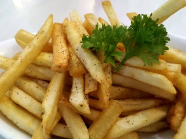 KUALA LUMPUR, MALAYSIA - 2 Şubat 2021: Beyaz bir tabağa yerleştirilmiş patates kızartmalarına odaklanmış. Müşterilere servis edilmeye hazır.