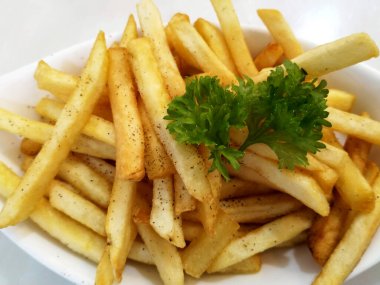 KUALA LUMPUR, MALAYSIA - 2 Şubat 2021: Beyaz bir tabağa yerleştirilmiş patates kızartmalarına odaklanmış. Müşterilere servis edilmeye hazır.