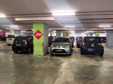MELAKA, MALAYSIA - 5 Nisan 2021: Binanın içindeki otoparktaki durum. Araçlar park yerindeki kutuya göre park edilmiş ve park alanı da sütundaki boyayla işaretlenmiş..
