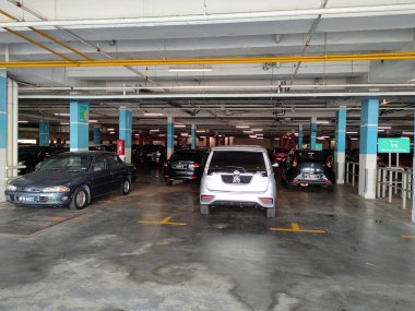 MELAKA, MALAYSIA - 5 Nisan 2021: Binanın içindeki otoparktaki durum. Araçlar park yerindeki kutuya göre park edilmiş ve park alanı da sütundaki boyayla işaretlenmiş..