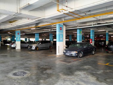 MELAKA, MALAYSIA - 5 Nisan 2021: Binanın içindeki otoparktaki durum. Araçlar park yerindeki kutuya göre park edilmiş ve park alanı da sütundaki boyayla işaretlenmiş..