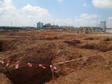SEPANG, MALAYSIA -MAYIS 06, 2014: İnşaat alanında ilerleme üzerine yığılma kapağı vakfı çalışması. İnşaat işçileri, kazma kapağı yapımına başlamak için delik kazıyorlar.. 