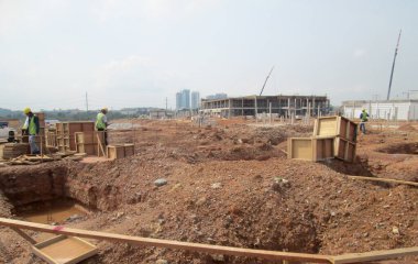 SEPANG, MALAYSIA -MAYIS 06, 2014: İnşaat alanında ilerleme üzerine yığılma kapağı vakfı çalışması. İnşaat işçileri, kazma kapağı yapımına başlamak için delik kazıyorlar.. 