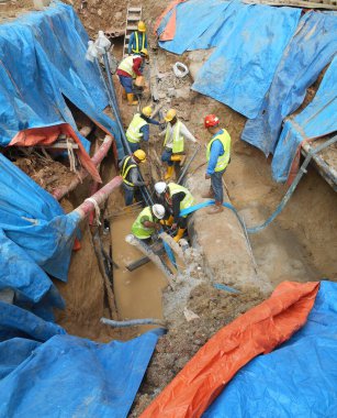 SELANGOR, MALAYSIA -HAZİRAN 03, 2017: yeraltı araçları ve drenaj siperleri. İnşaat işçileri makineleri kullanarak hendek kazıyor ve yeraltında beton kanalizasyonu ve elektrik tesisatını kullanıyor..  