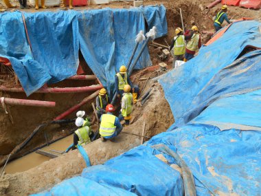 SELANGOR, MALAYSIA -HAZİRAN 03, 2017: yeraltı araçları ve drenaj siperleri. İnşaat işçileri makineleri kullanarak hendek kazıyor ve yeraltında beton kanalizasyonu ve elektrik tesisatını kullanıyor..  