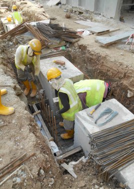 SELANGOR, MALAYSIA - 02 Aralık 2016: İnşaat işçileri inşaat alanında inşaat öncesi beton drenaj döşüyorlar. 