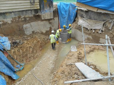 SELANGOR, MALAYSIA - 02 Aralık 2016: İnşaat işçileri inşaat alanında inşaat öncesi beton drenaj döşüyorlar. 