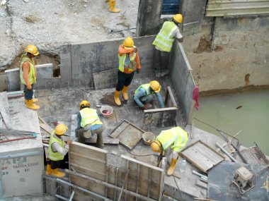 SELANGOR, MALAYSIA - 02 Aralık 2016: İnşaat işçileri inşaat alanında inşaat öncesi beton drenaj döşüyorlar. 