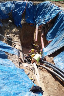 SELANGOR, MALAYSIA -HAZİRAN 03, 2017: yeraltı araçları ve drenaj siperleri. İnşaat işçileri makineleri kullanarak hendek kazıyor ve yeraltında beton kanalizasyonu ve elektrik tesisatını kullanıyor..  