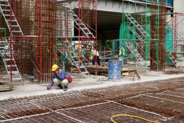 PENANG, MALAYSIA - 4 Mart 2020: döşeme plakaları bir inşaat sahasında yapım aşamasında. İşçiler, beton dökülmeden önce keresteye çelik takviyesi yapmakla meşguldü..