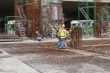 PENANG, MALAYSIA - 4 Mart 2020: döşeme plakaları bir inşaat sahasında yapım aşamasında. İşçiler, beton dökülmeden önce keresteye çelik takviyesi yapmakla meşguldü..