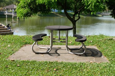 MELAKA, MALAYSIA - 29 Mart 2021: Kamu alanlarında ve parklarda kamu bankları inşa edilmiştir. Yorgunluğu azaltmak, rahatlamak ya da sosyalleşmek için kullanılır. Havaya dayanıklı malzemeler kullanılarak yapıldı..