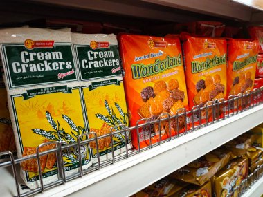 JOHOR, MALAYSIA -20 Haziran 2021: Bisküvilerin çeşitliliği iyi ve ilginç paketleme ve mağazanın içindeki raflarda sergilendi. Müşterilerin satın almasını kolaylaştırmak için markaya göre sırala.