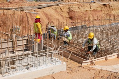 SELANGOR, MALAYSIA -5 Nisan 2021: İnşaat işçileri bir inşaat sahasında çalışıyorlar. Güvenlik kaskı ve güvenlik yelekleri gibi güvenlik ekipmanları giymeleri gerekiyor.