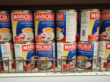 SELANGOR, MALAYSIA -4 Nisan 2022: tatlandırılmış krema ve buharlaştırılmış süt kutularda paketlendi. Süpermarketin içindeki rafta satılık. Ana bileşen palmiye yağı tohumlarından yapılır..