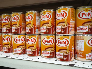 SELANGOR, MALAYSIA -4 Nisan 2022: tatlandırılmış krema ve buharlaştırılmış süt kutularda paketlendi. Süpermarketin içindeki rafta satılık. Ana bileşen palmiye yağı tohumlarından yapılır..