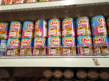 SELANGOR, MALAYSIA -4 Nisan 2022: tatlandırılmış krema ve buharlaştırılmış süt kutularda paketlendi. Süpermarketin içindeki rafta satılık. Ana bileşen palmiye yağı tohumlarından yapılır..