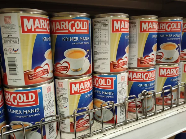 SELANGOR, MALAYSIA -4 Nisan 2022: tatlandırılmış krema ve buharlaştırılmış süt kutularda paketlendi. Süpermarketin içindeki rafta satılık. Ana bileşen palmiye yağı tohumlarından yapılır..
