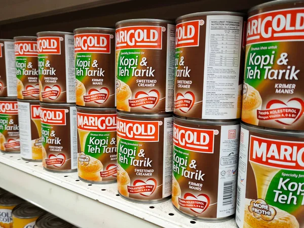 SELANGOR, MALAYSIA -4 Nisan 2022: tatlandırılmış krema ve buharlaştırılmış süt kutularda paketlendi. Süpermarketin içindeki rafta satılık. Ana bileşen palmiye yağı tohumlarından yapılır..