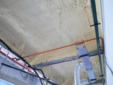 SELANGOR, MALAYSIA - 10 Mart 2022: poliüretan yalıtım köpüğü püskürtülmüş ve beton levhaların altındaki yüzeyi kaplamıştır. Binanın termal yalıtımı için bir katman görevi görür..