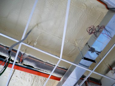 SELANGOR, MALAYSIA - 10 Mart 2022: poliüretan yalıtım köpüğü püskürtülmüş ve beton levhaların altındaki yüzeyi kaplamıştır. Binanın termal yalıtımı için bir katman görevi görür..