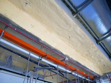 SELANGOR, MALAYSIA - 10 Mart 2022: poliüretan yalıtım köpüğü püskürtülmüş ve beton levhaların altındaki yüzeyi kaplamıştır. Binanın termal yalıtımı için bir katman görevi görür..