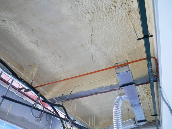 SELANGOR, MALAYSIA - 10 Mart 2022: poliüretan yalıtım köpüğü püskürtülmüş ve beton levhaların altındaki yüzeyi kaplamıştır. Binanın termal yalıtımı için bir katman görevi görür..
