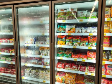SELANGOR, MALAYSIA - 15 Nisan 2021: Dev süpermarketteki soğutucu buzdolabının içine yerleştirilmiş çeşitli markalarda tavuk nugget ticari ambalajına odaklanmış.